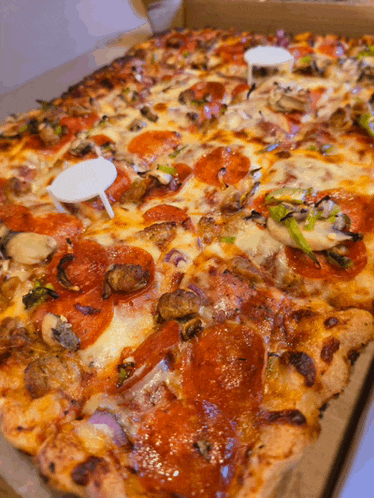 a large pizza with pepperoni mushrooms and cheese in a box