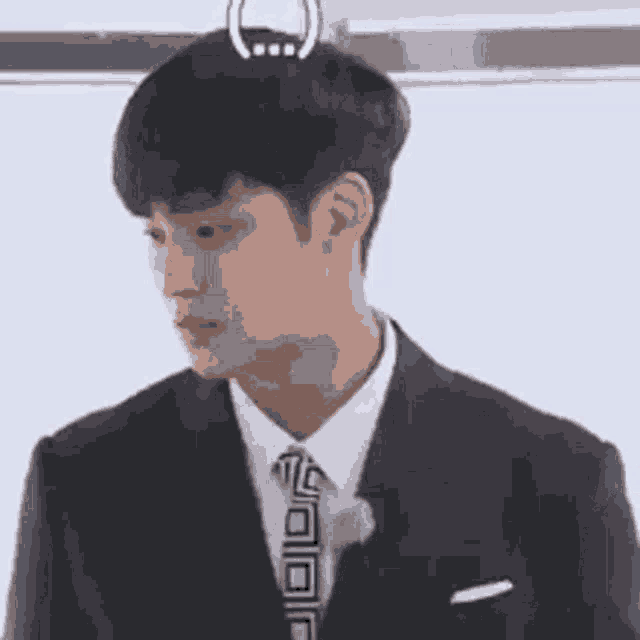 a man in a suit and tie is looking down .