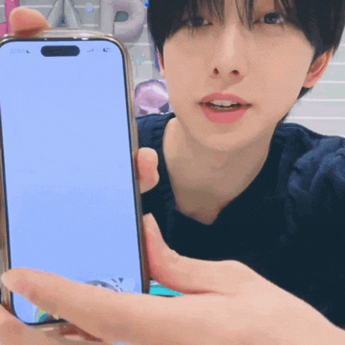 a man is holding a cell phone with a blank screen