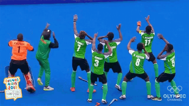 a group of hockey players are dancing on a blue field with the olympic channel written on the bottom