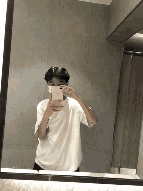 a person taking a selfie in a bathroom mirror