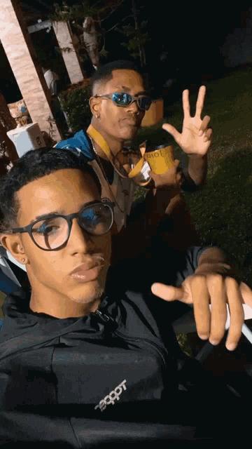 two young men are posing for a picture and one of them has a jacket that says " ecpot " on it