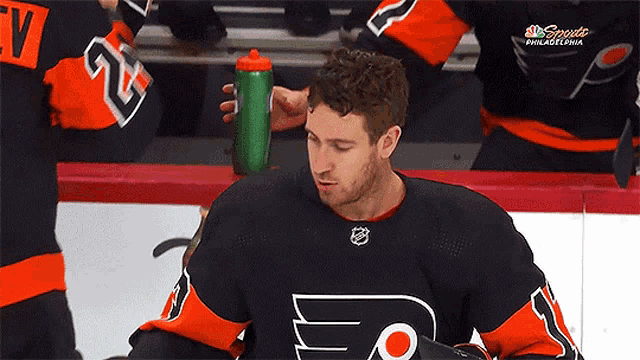 a philadelphia hockey player holds a water bottle