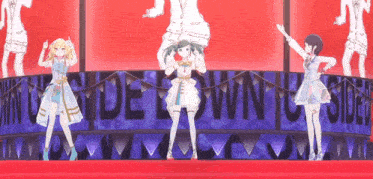 a group of anime girls are dancing on a stage in front of a banner that says side town to side