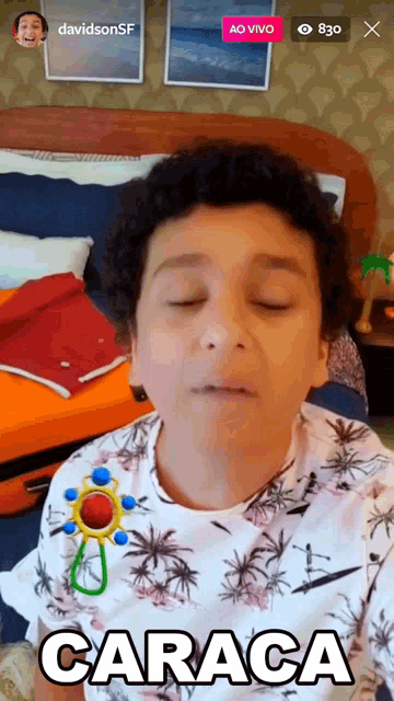 a boy wearing a shirt that says caraca is playing with a rattle