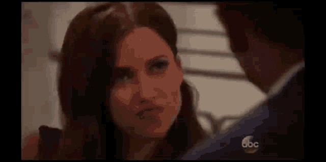 a man and a woman are looking at each other . the woman is making a funny face .