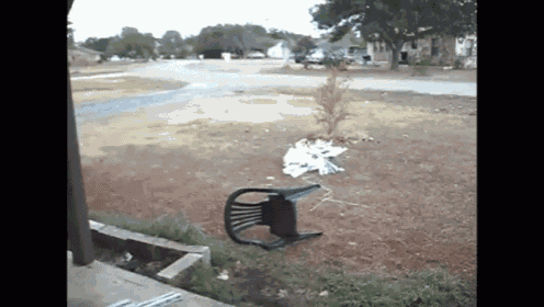 a broken chair sits on the ground in a residential area