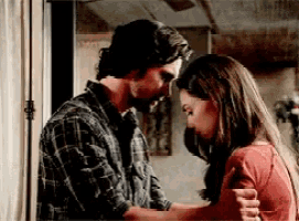 a man and a woman are standing next to each other and looking at each other .
