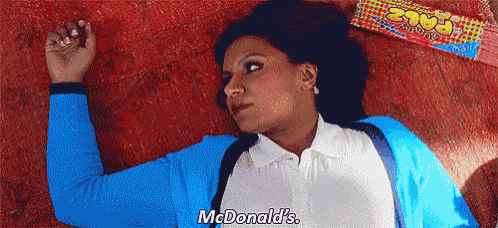 a woman laying on the floor next to a box of mcdonald 's candy
