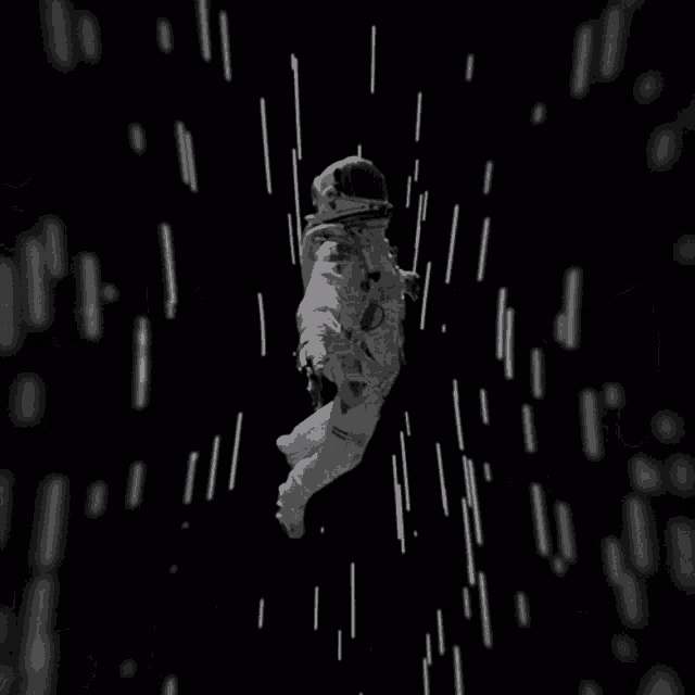 a black and white photo of an astronaut floating through space