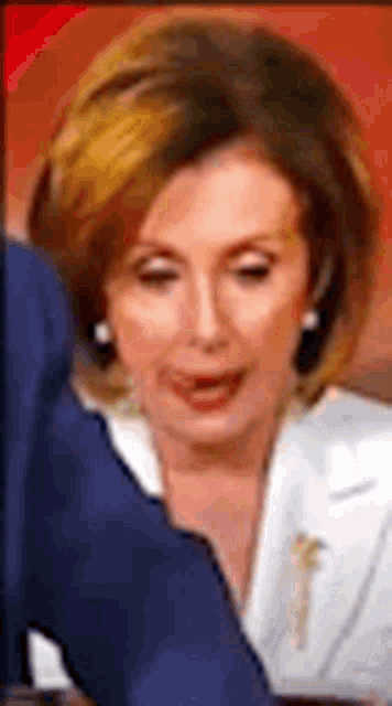 a close up of a woman in a white jacket talking to a man in a suit .
