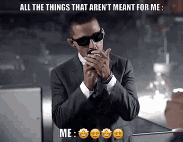 a man in a suit and sunglasses is smoking a cigarette and says all the things that aren 't meant for me me