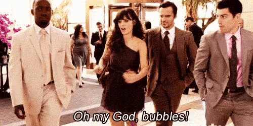 a group of people in suits are walking down a street and one of them is saying `` oh my god , bubbles '' .