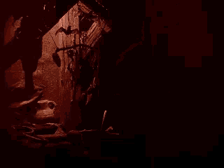 a naked man with horns is sitting on a chair in a dark room holding an axe .