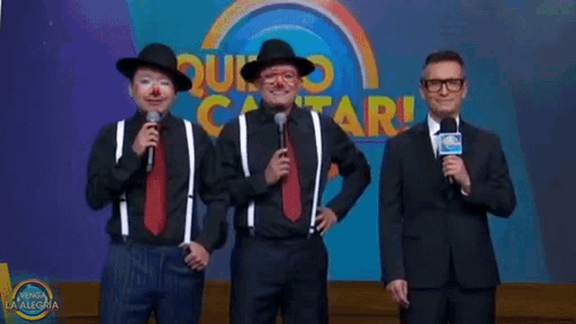 three clowns singing into microphones in front of a sign that says ' quito cantar '
