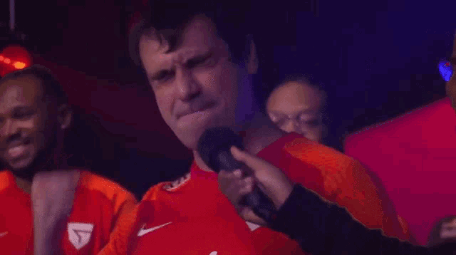 a man in a red nike shirt is being interviewed