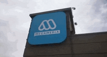 a blue megamedia logo is on top of a building .