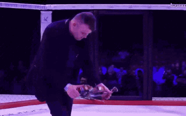 a man in a boxing ring is holding a bow and arrow in his hand