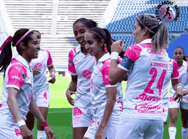 a group of female soccer players wearing pink jerseys with the number 24 on them