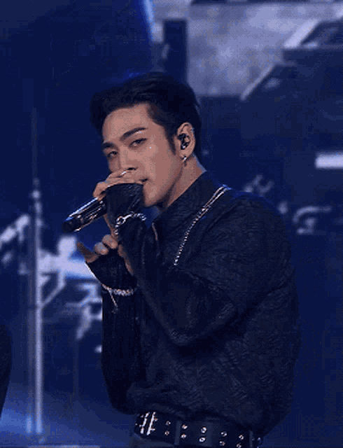 a man is singing into a microphone while wearing ear buds