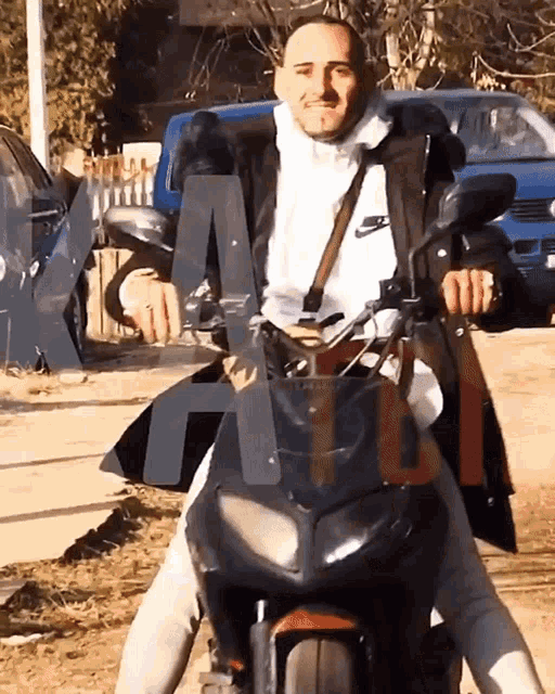 a man sitting on a motorcycle with the letter a visible