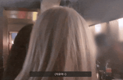 a woman 's head is shown in a blurry photo with korean writing on the bottom right