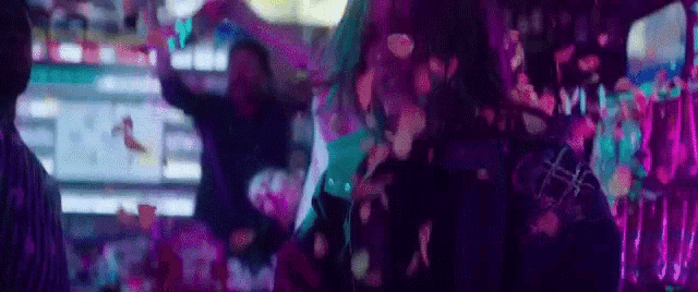 a group of people are dancing at a party in a dark room .