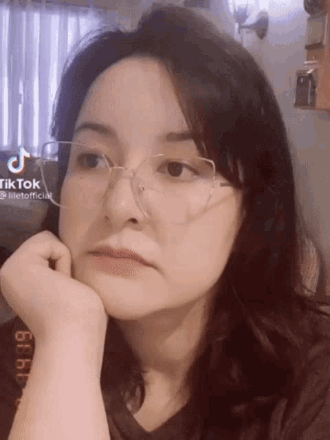 a woman wearing glasses and a tiktok logo on her face
