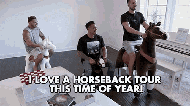 three men are riding stuffed horses and unicorns in a living room