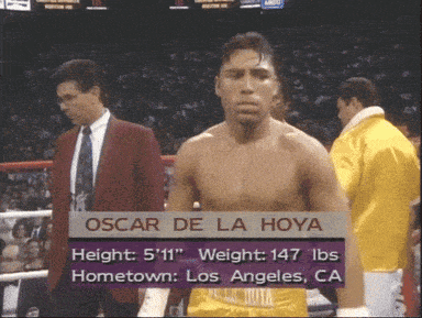 oscar de la hoya is standing in a boxing ring in front of a crowd