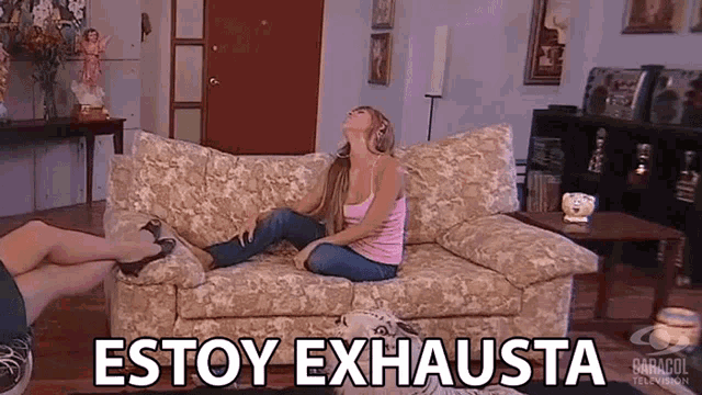 a woman is sitting on a couch with the words estoy exhausta written on it