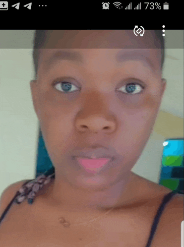 a woman 's face is shown on a phone screen with a 73 % battery level