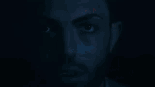 a close up of a person 's eye with a blue light reflecting in it .