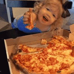 a little girl is eating a slice of pizza from a cardboard box