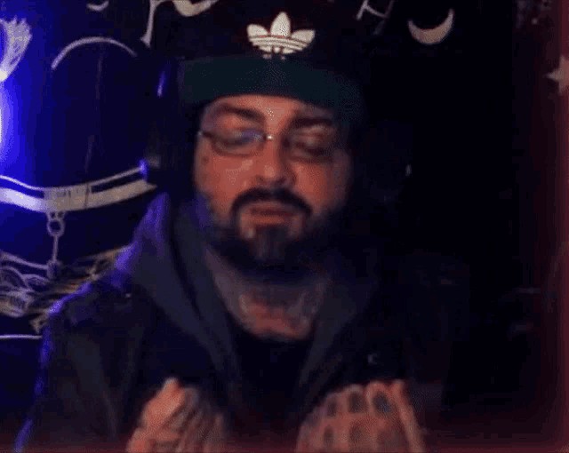 a man with a beard wearing headphones and a hat that says perfect
