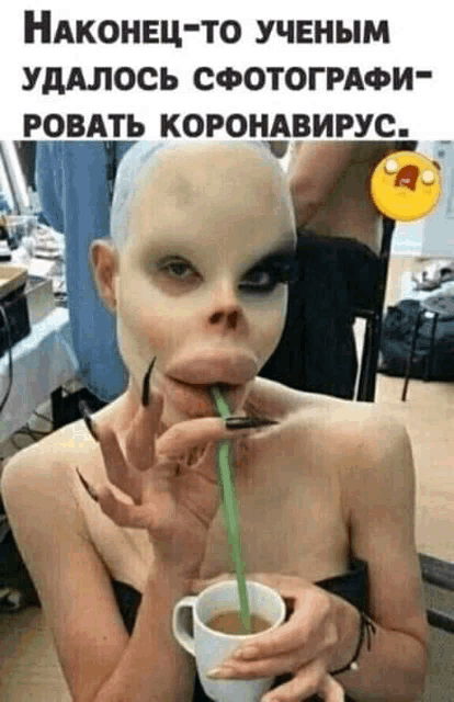 a woman with a mask on her face is drinking from a cup through a straw .