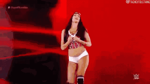 a woman in a wrestling outfit is standing on a red background .