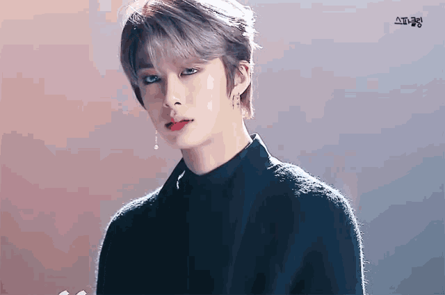 a young man with gray hair is wearing a black sweater and red lipstick .