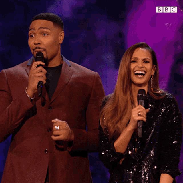 a man and a woman are standing next to each other on a stage with a bbc logo in the corner