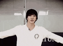 a young man with his arms outstretched is wearing a white shirt .