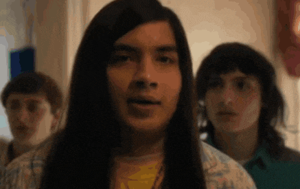 a group of young men with long hair are standing next to each other .