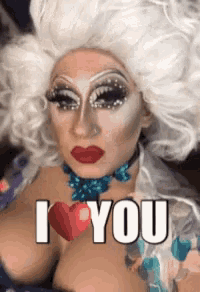 a drag queen with white hair and red lips says " i love you "