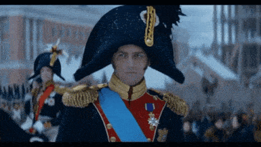 a man in a military uniform with a blue sash around his neck