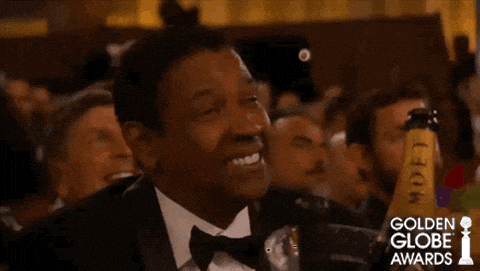 a man in a tuxedo is smiling in front of a bottle of moet champagne