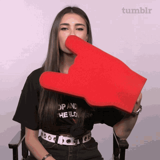 a woman wearing a black shirt that says " op and the lower " is holding a red hand