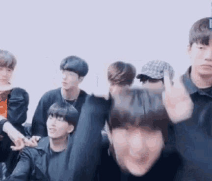 a group of young men are standing next to each other and making funny faces .