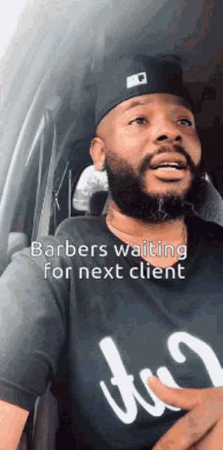 a man sitting in a car with the words barbers waiting for next client on the bottom