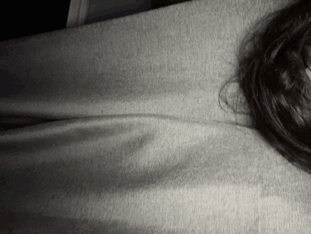 a close up of a person laying on a gray cloth