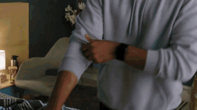 a man in a white shirt has his sleeves up