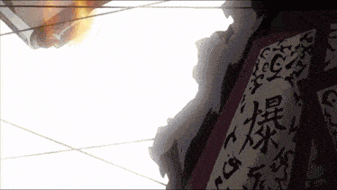 a sign with chinese writing on it is hanging from a building